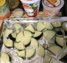 Chopped eggplant on tray with food containers.