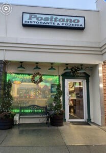 Italian restaurant entrance with green decorations.