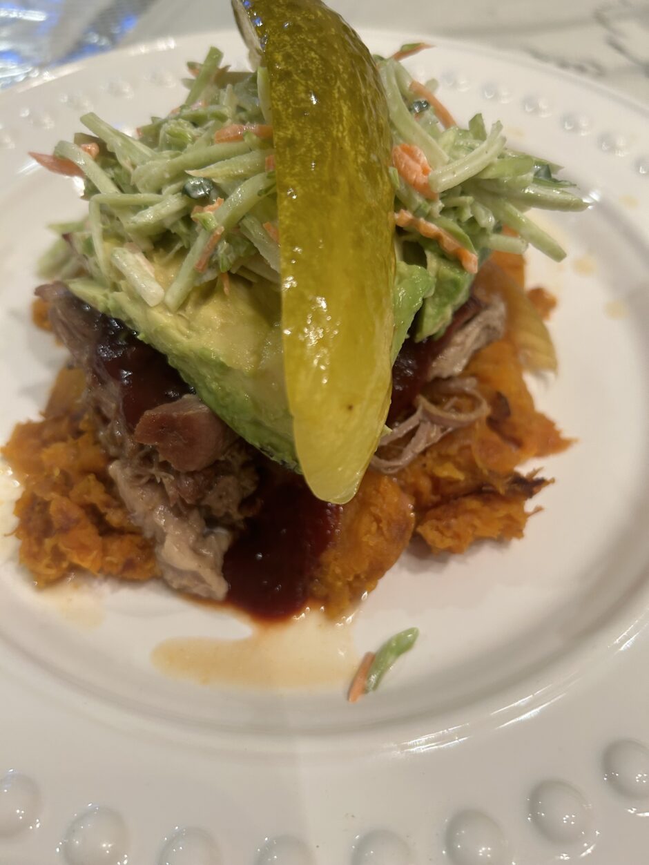 Plate with shredded beef, pickles, and coleslaw.